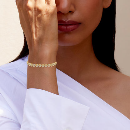 10K yellow gold diamond heart bracelet displayed on a woman's wrist for elegant accessorizing