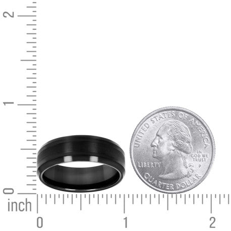 Black tungsten wedding band displayed next to a quarter for size reference